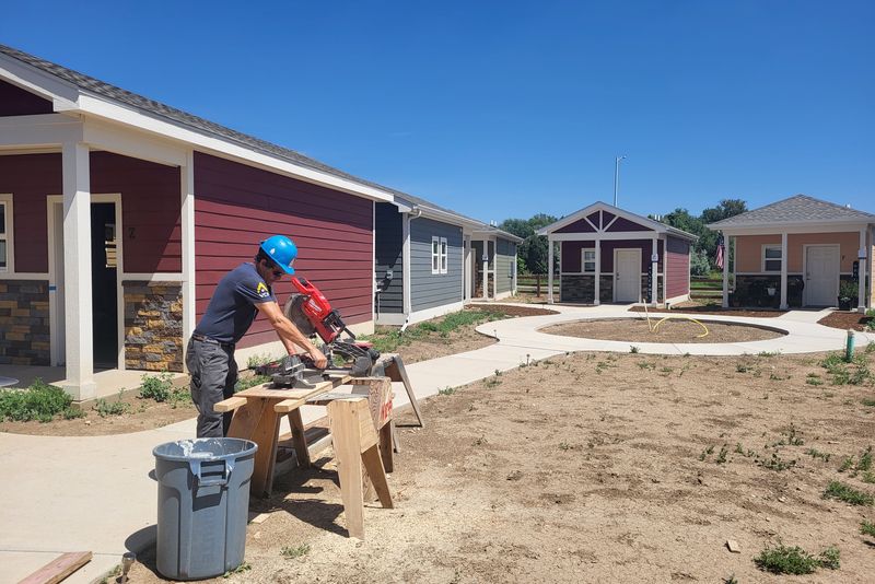 A volunteer cutting lumber in the Veterans Community Project tiny home village